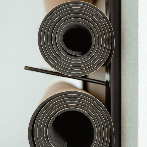 Neatly rolled yoga mat and a water bottle in a calm room.